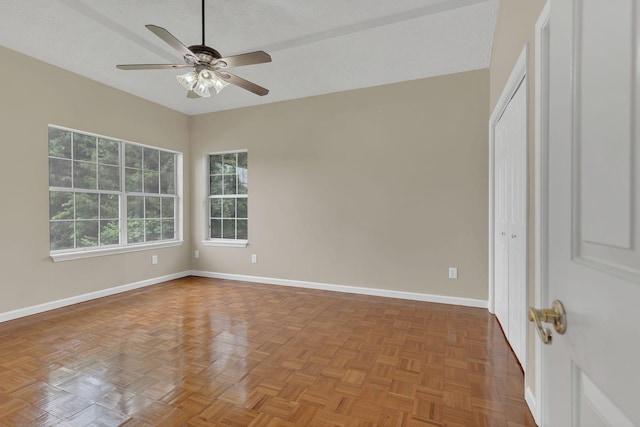 empty room with ceiling fan and baseboards