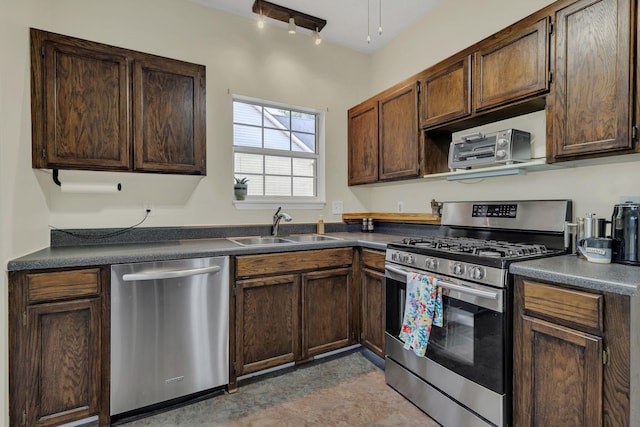 kitchen with stainless steel appliances, a sink, dark countertops, and dark brown cabinets