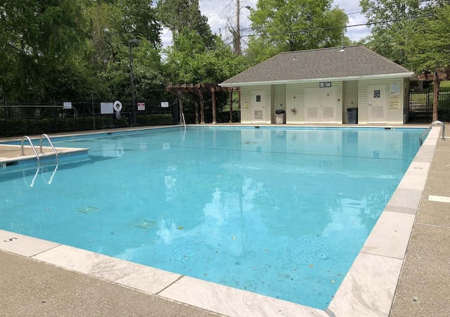 community pool featuring fence and view of wooded area