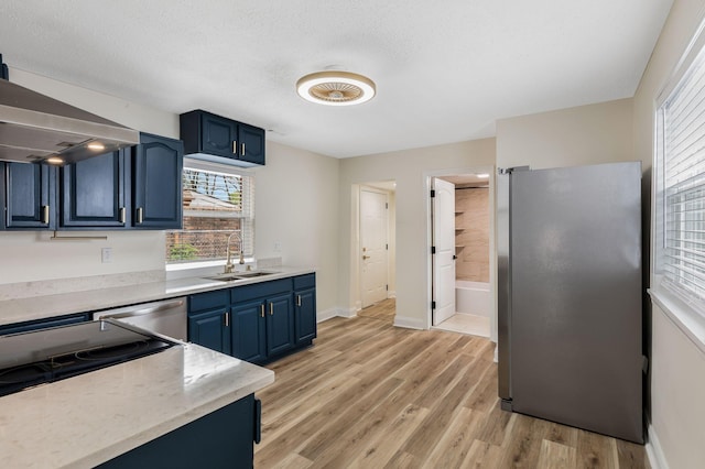 1607 Wheless St, Nashville, TN 37208 - kitchen featuring a sink, appliances with stainless steel finishes, blue cabinets, light wood-style flooring, and light countertops