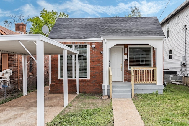 1607 Wheless St, Nashville, TN 37208 - entrance to property featuring a shingled roof, brick siding, central AC, and a carport
