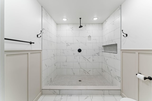 full bathroom featuring marble finish flooring, tiled shower, and recessed lighting