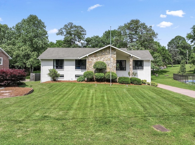 view of front of home with a front lawn, brick siding, and a shingled roof