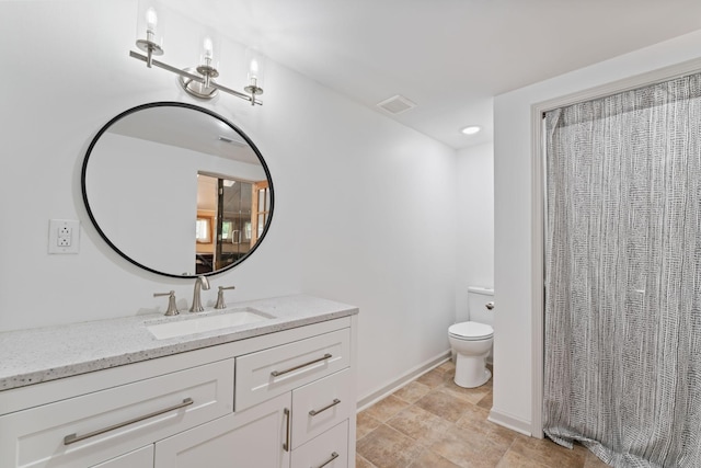 bathroom with toilet, vanity, and baseboards
