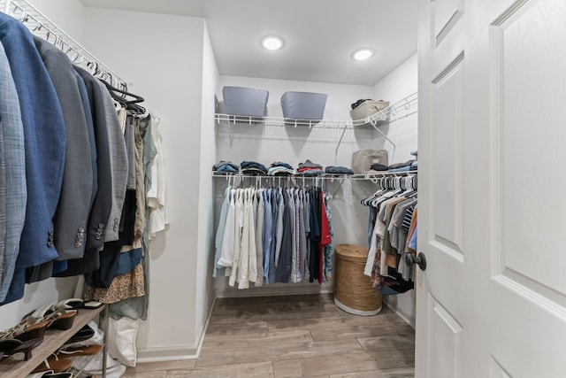 walk in closet with wood finished floors