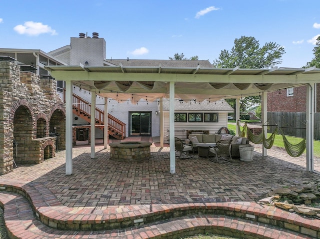 view of patio / terrace featuring an outdoor living space with a fire pit, fence, and stairs