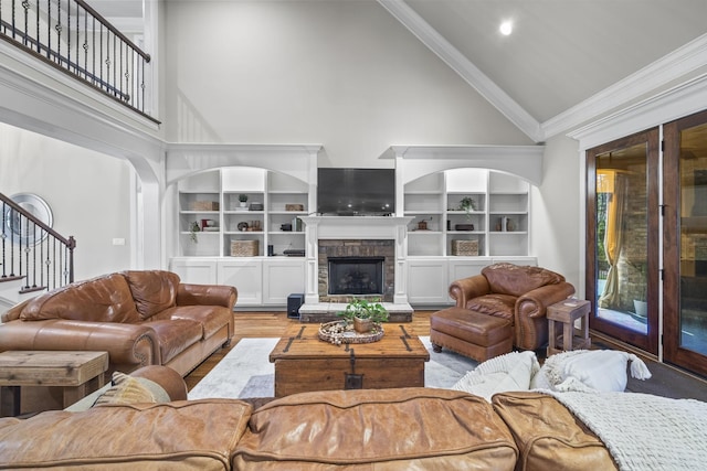 2979 Stewart Campbell Pt, Spring Hill, TN 37174 - living area with high vaulted ceiling, stairway, wood finished floors, a stone fireplace, and crown molding