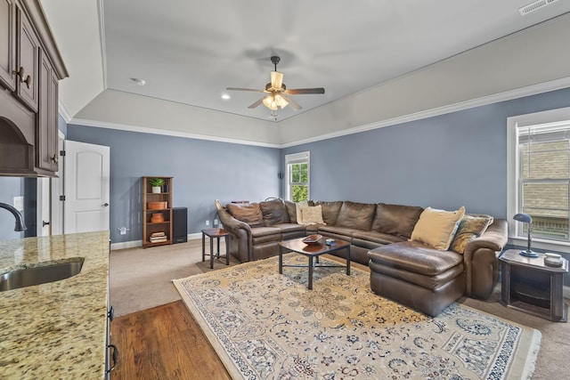 2979 Stewart Campbell Pt, Spring Hill, TN 37174 - living room with a ceiling fan, dark carpet, crown molding, baseboards, and a raised ceiling