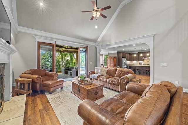 2979 Stewart Campbell Pt, Spring Hill, TN 37174 - living area featuring light wood-style floors, a fireplace with raised hearth, a ceiling fan, high vaulted ceiling, and ornamental molding