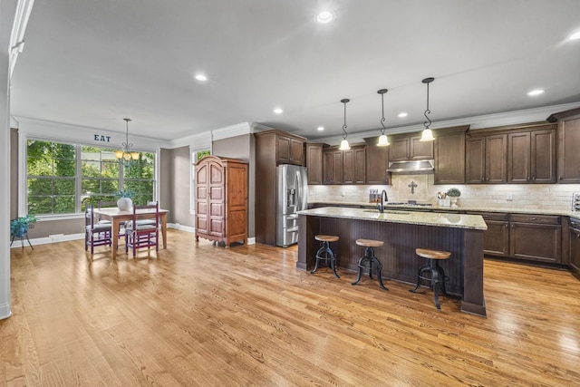 2979 Stewart Campbell Pt, Spring Hill, TN 37174 - kitchen with under cabinet range hood, stainless steel fridge with ice dispenser, ornamental molding, light wood-style floors, and baseboards