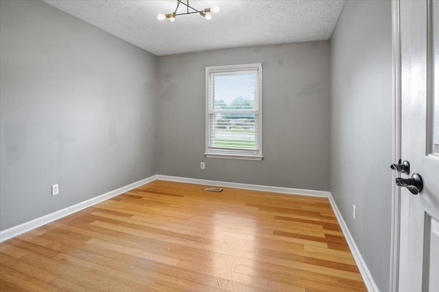 1306 Cason Trl, Murfreesboro, TN 37128 - unfurnished room featuring a chandelier, a textured ceiling, light wood finished floors, and baseboards