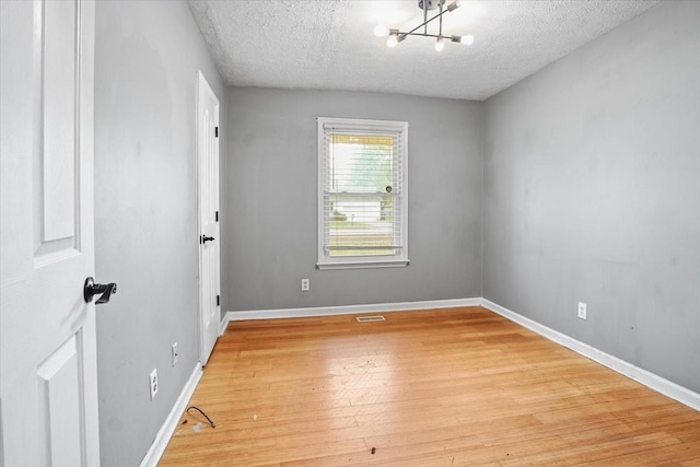 1306 Cason Trl, Murfreesboro, TN 37128 - empty room featuring a chandelier, light wood-style flooring, a textured ceiling, and baseboards