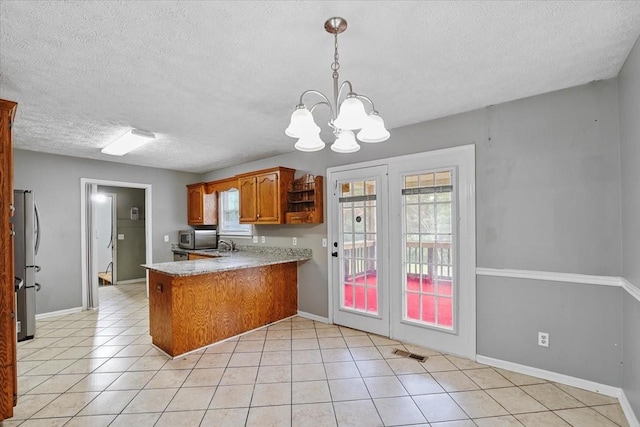 1306 Cason Trl, Murfreesboro, TN 37128 - kitchen featuring stainless steel appliances, a peninsula, brown cabinetry, a textured ceiling, and light countertops