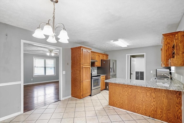 1306 Cason Trl, Murfreesboro, TN 37128 - kitchen featuring appliances with stainless steel finishes, brown cabinetry, a sink, a chandelier, and a textured ceiling