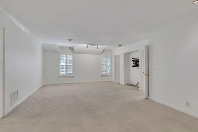 unfurnished room with ornamental molding, light carpet, baseboards, and rail lighting