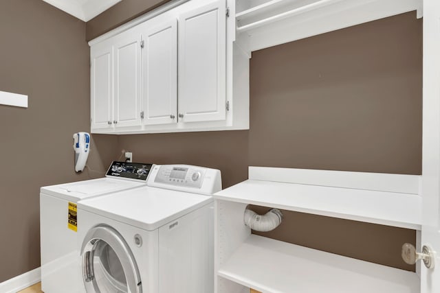 clothes washing area featuring cabinet space and independent washer and dryer
