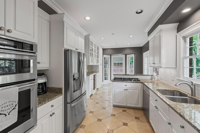 kitchen featuring stainless steel appliances, a sink, white cabinets, backsplash, and recessed lighting