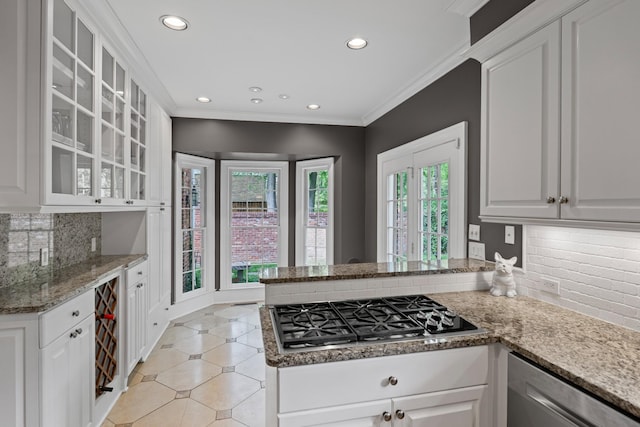 kitchen featuring appliances with stainless steel finishes, recessed lighting, a peninsula, glass insert cabinets, and white cabinetry