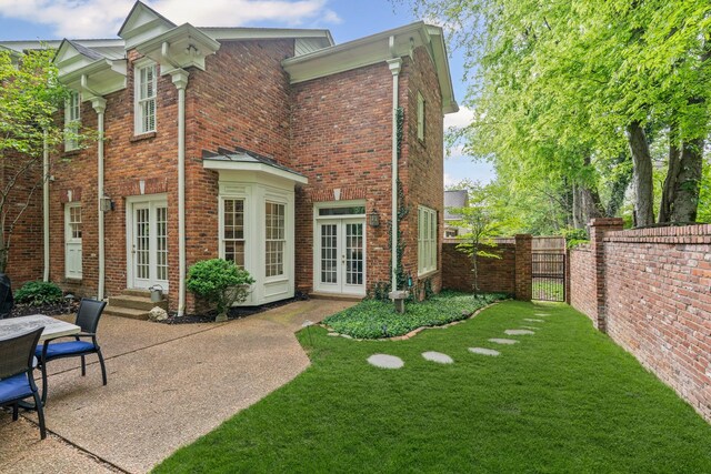 back of property featuring french doors, a gate, entry steps, brick siding, and a patio area