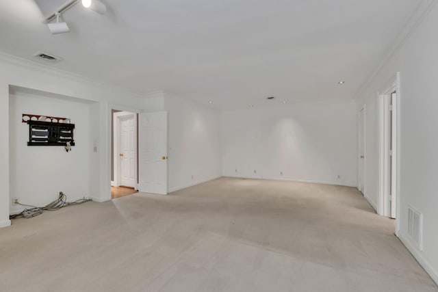 unfurnished room featuring light colored carpet, crown molding, and baseboards