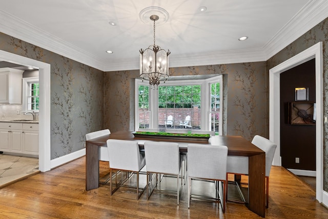 dining space with a chandelier, light wood-style floors, wallpapered walls, recessed lighting, and crown molding
