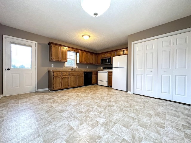 202 Jenna Ave, Oak Grove, KY 42262 - kitchen with freestanding refrigerator, stove, black dishwasher, stainless steel microwave, and a textured ceiling