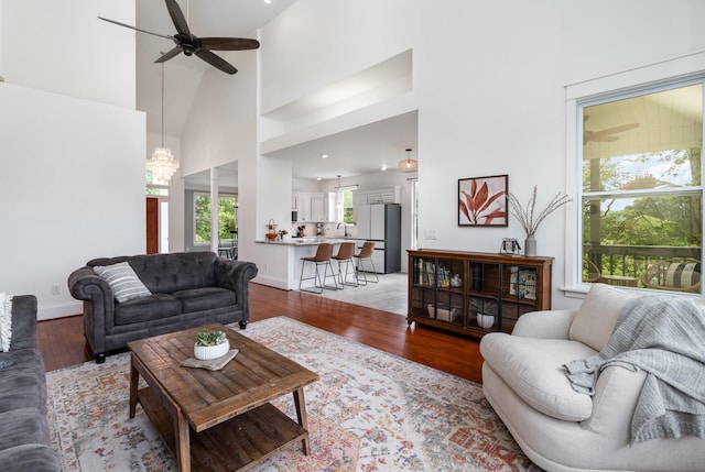 4851 Bethesda Duplex Rd, College Grove, TN 37046 - living area with ceiling fan, a towering ceiling, light wood-type flooring, baseboards, and a chandelier