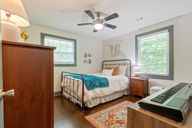 bedroom featuring multiple windows, dark wood finished floors, and a ceiling fan