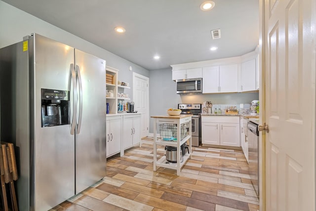 kitchen featuring appliances with stainless steel finishes, open shelves, white cabinetry, recessed lighting, and light wood-style flooring