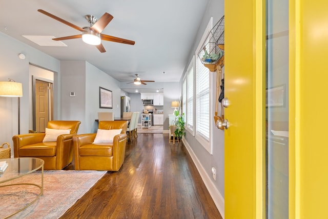 living room with a ceiling fan, dark wood finished floors, and baseboards