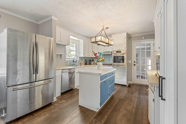 kitchen with stainless steel appliances, blue cabinetry, a sink, a center island, and white cabinets