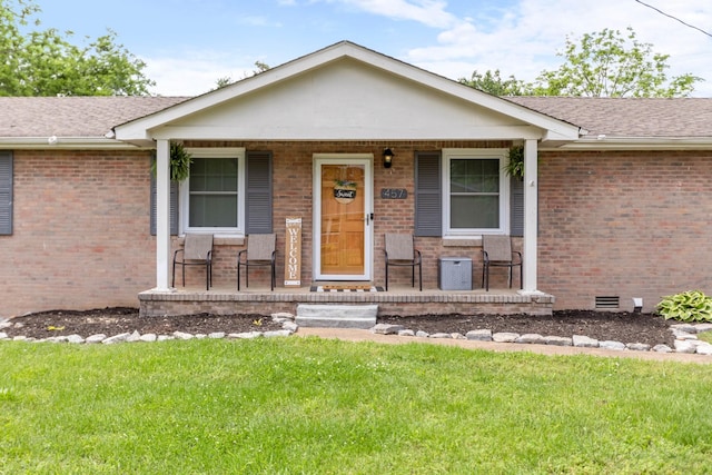 view of front facade featuring covered porch, brick siding, and a front lawn