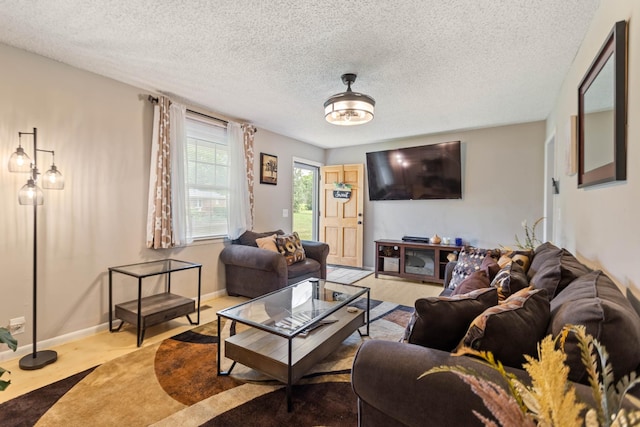 living room with a textured ceiling and baseboards