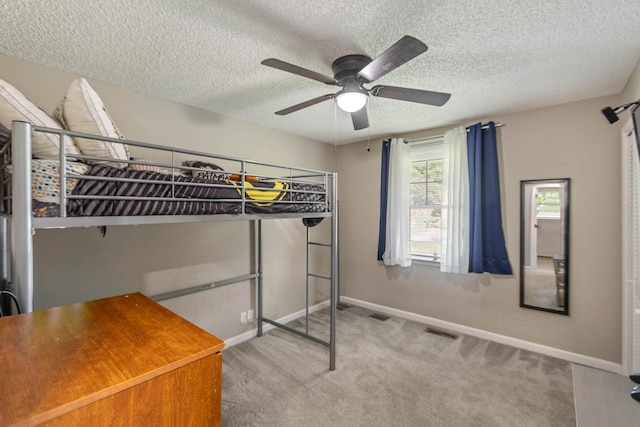 unfurnished bedroom with carpet floors, baseboards, a textured ceiling, and ceiling fan