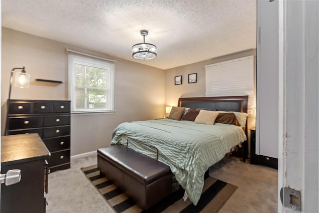carpeted bedroom featuring a textured ceiling and baseboards