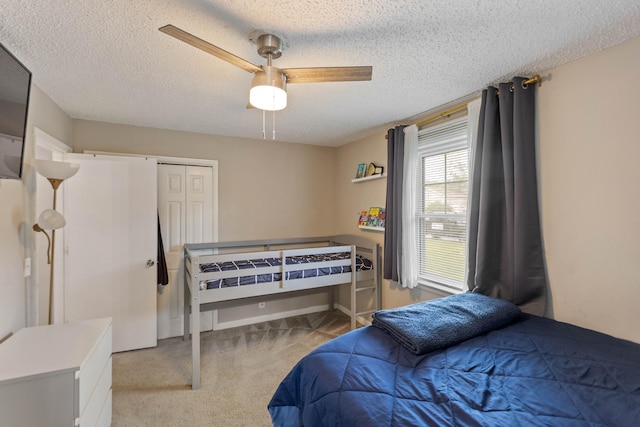bedroom featuring carpet flooring, a textured ceiling, and ceiling fan