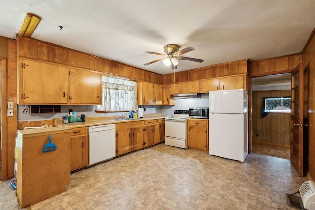 2732 Wayside Rd, Manchester, TN 37355 - kitchen featuring white appliances, wood walls, under cabinet range hood, ceiling fan, and light countertops