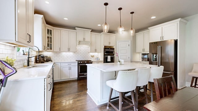 203 W Chandler Ct, Mount Juliet, TN 37122 - kitchen featuring premium appliances, a center island, a kitchen bar, tasteful backsplash, and dark wood-type flooring