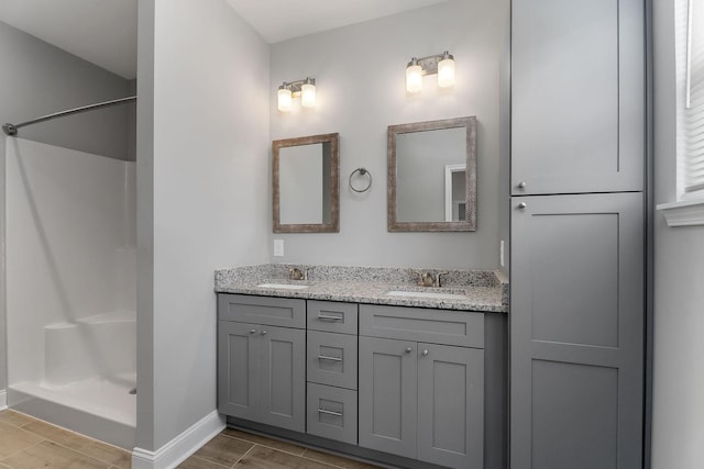 201 Hayes St, Smithville, TN 37166 - full bathroom with wood finish floors, a shower, double vanity, and baseboards