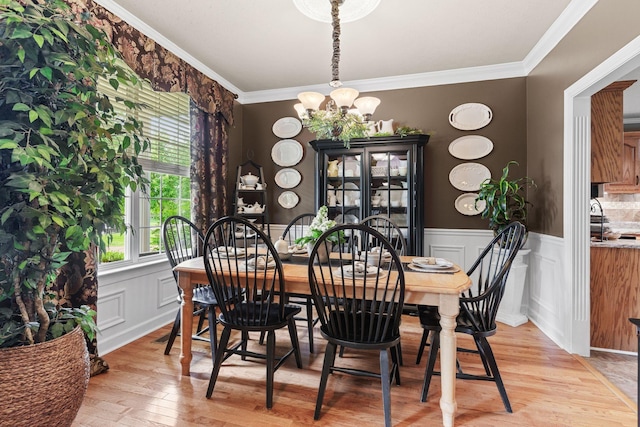 102 Lorelle Cir, Portland, TN 37148 - dining area with a chandelier, a wainscoted wall, light wood finished floors, crown molding, and a decorative wall