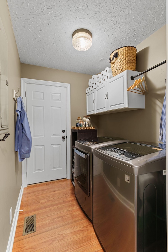 102 Lorelle Cir, Portland, TN 37148 - clothes washing area featuring cabinet space, separate washer and dryer, light wood finished floors, a textured ceiling, and baseboards