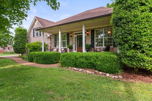 102 Lorelle Cir, Portland, TN 37148 - view of front facade featuring covered porch, a front lawn, a shingled roof, and brick siding