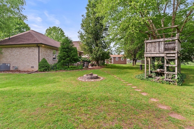 102 Lorelle Cir, Portland, TN 37148 - view of green lawn featuring a fire pit, a wooden deck, and central air condition unit
