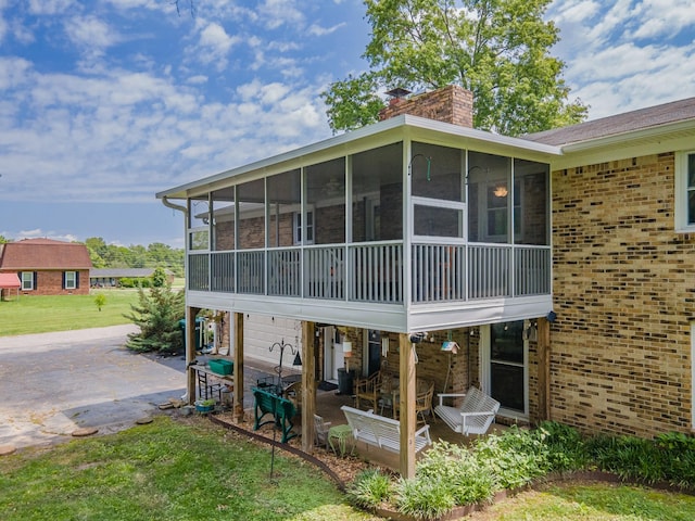 1205 Parker Dr, Pulaski, TN 38478 - back of house featuring a sunroom, a patio, brick siding, and a chimney