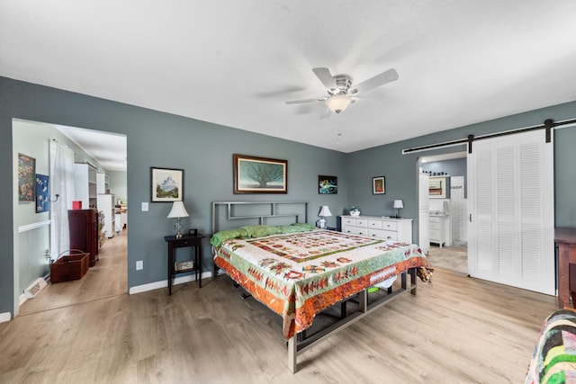 1205 Parker Dr, Pulaski, TN 38478 - bedroom featuring a barn door, light wood-style floors, baseboards, and ceiling fan