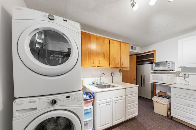 1205 Parker Dr, Pulaski, TN 38478 - laundry room featuring estacked washer and dryer, dark carpet, a textured ceiling, and cabinet space