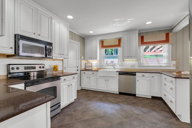 220 Porters Bluff Rd, Clarksville, TN 37040 - kitchen featuring appliances with stainless steel finishes, a sink, white cabinets, ornamental molding, and tasteful backsplash