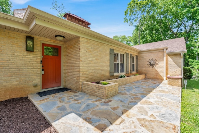 220 Porters Bluff Rd, Clarksville, TN 37040 - doorway to property with brick siding, a chimney, a patio area, and roof with shingles