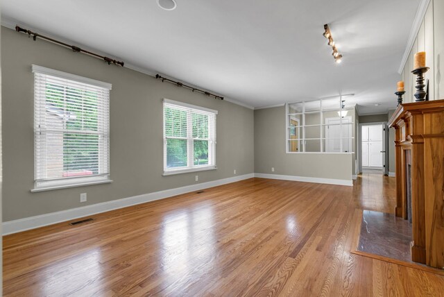 220 Porters Bluff Rd, Clarksville, TN 37040 - unfurnished living room with rail lighting, baseboards, and light wood finished floors