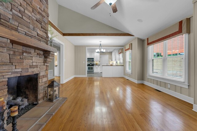 220 Porters Bluff Rd, Clarksville, TN 37040 - unfurnished living room featuring light wood-style flooring, lofted ceiling, ceiling fan, a chandelier, and a fireplace